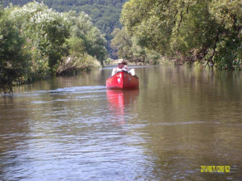 Rotes Kanu auf ruhiger Flussstrecke bei Schlitz