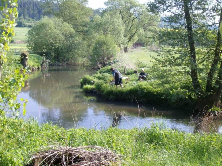 Angler an der Schlitz in grüner Auenlandschaft