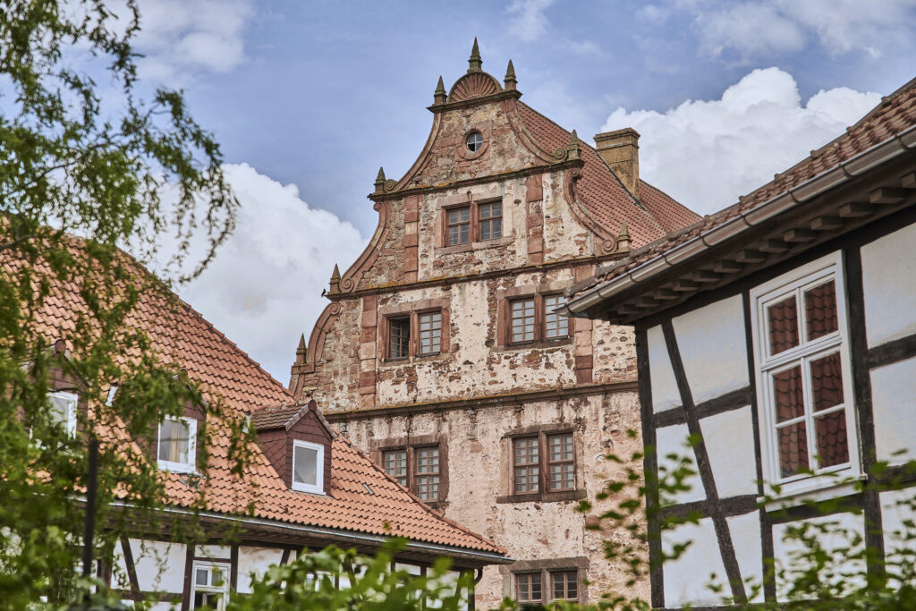 Fachwerkhäuser rahmen einen verwitterten Ziergiebel der Schlitzer Vorderburg.